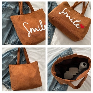 Detail of caramel corduroy tote bag showing spacious interior and Smile print texture