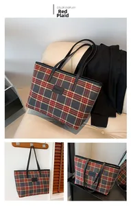 Close-up of vintage red plaid tote bag with brand logo patch and black leather straps