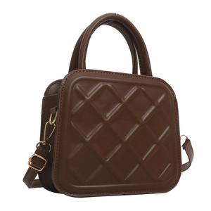 Quilted dark brown crossbody bag with top handle and golden hardware on white background