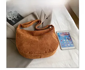 Detail of caramel corduroy shoulder bag with Sport leather label and spacious interior
