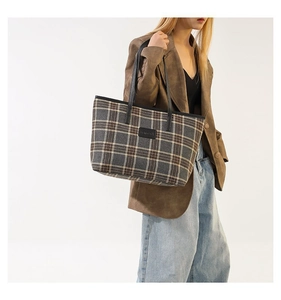 Detail of the vintage plaid tote bag featuring leather shoulder straps and textured wool fabric