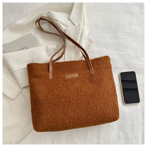 Détail d'un cabas marron en peluche avec étiquette en cuir et texture très douce
