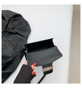 Detail showing the inner structure and silver magnetic buckle of the black square bag
