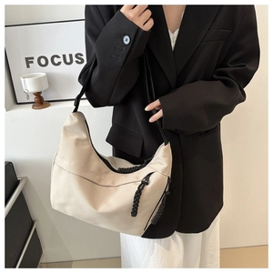 Minimalist beige dumpling hobo bag with contrast black shoulder strap and large capacity