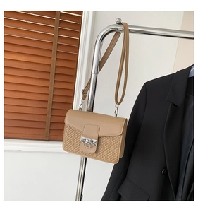 Close-up of khaki square crossbody bag featuring embossed woven texture and silver ring buckle