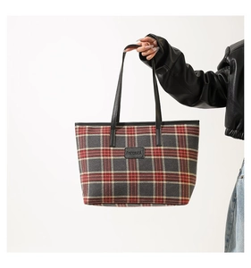 Detail of red and grey plaid tote bag with black leather handles and FrancescA logo tag