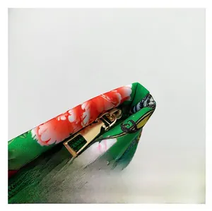 Detailed close-up of a smooth gold metal zipper on a floral nylon ethnic handbag