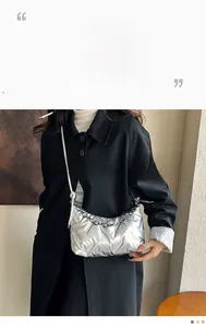 Détail du sac à main croissant argenté avec texture matelassée et chaîne en métal
