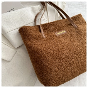 Détail du sac fourre-tout en polaire pelucheuse avec anses en cuir et écusson mode