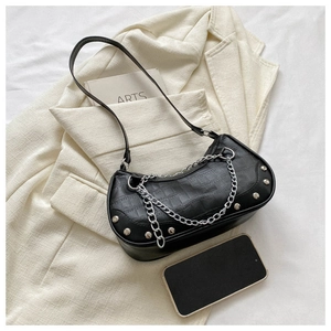 Détail du sac noir à motif crocodile avec clous argentés et chaîne décorative chic