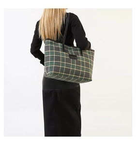 Plaid tote bag showing large capacity and textured fabric on model's shoulder