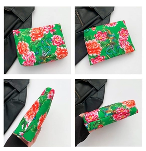 Detail of green nylon makeup bag with traditional red peony and phoenix prints