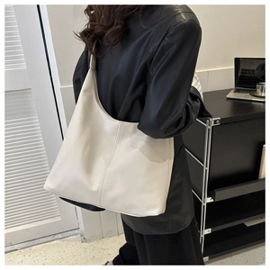 Minimalist cream white hobo bag shown with model for large capacity and modern drape style