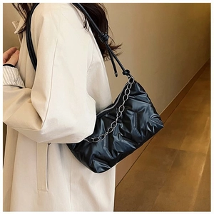 Détail du sac à bandoulière matelassé noir avec texture bouffante et chaîne