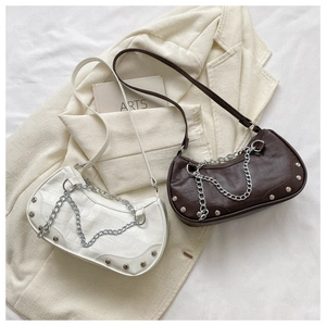 Détail de sacs blanc et marron avec texture crocodile et éléments de chaîne en métal argenté