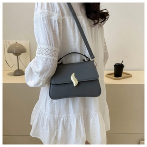 Vue détaillée du sac bandoulière gris foncé avec fermoir feuille dorée et cuir synthétique