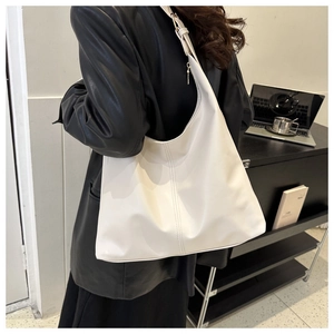 Detailed side view of white large capacity hobo bag with gold hardware for office use