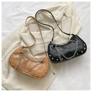 Détail de sacs sous le bras à motif de pierre avec chaîne argentée et rivets en noir et brun