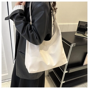 Model showing off white minimalist faux leather hobo shoulder bag with silver side zipper