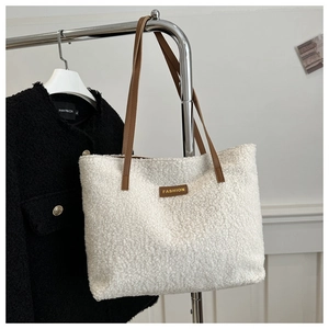 Bolso tote de pelo blanco minimalista con correas de cuero marrón y etiqueta de moda