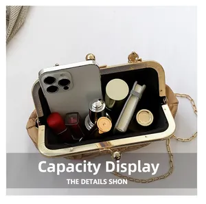 Top view of cream textured kiss-lock bag showing internal capacity with phone and lipstick