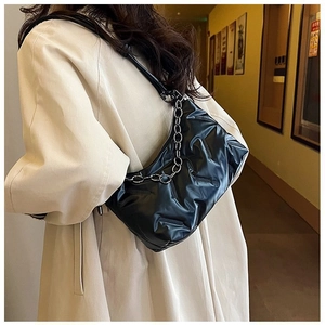 Sac sous les aisselles matelassé noir plissé avec chaîne argentée porté par un mannequin