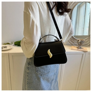 Détail d'un élégant sac bandoulière en cuir noir avec boucle dorée et bandoulière fine