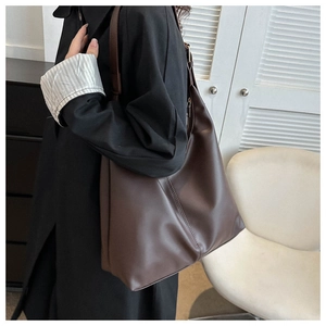 Detail view of large dark brown tote bag with contrast stitching and adjustable strap