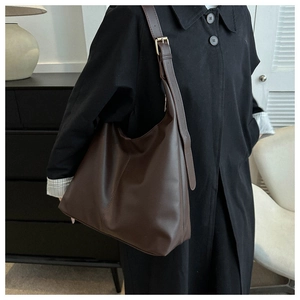 Detail view of large dark brown hobo bag with adjustable metal buckle on shoulder strap