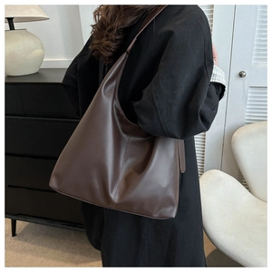 Detail view of large dark brown hobo shoulder bag with vertical stitching and smooth texture