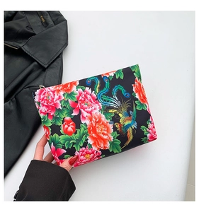 Detailed shot of ethnic floral print bag with golden zipper and phoenix patterns