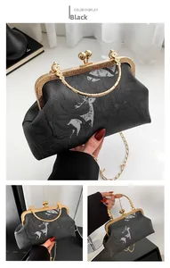 Detail of black vintage clutch with floral deer embossing and gold clasp handle