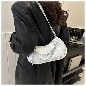 Vue détaillée du sac croissant blanc avec texture à motif de pierre et chaîne argentée