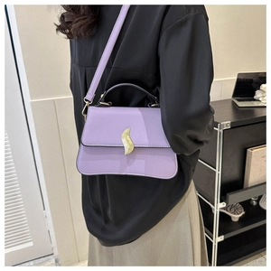 Détail d'un sac à main violet en similicuir avec boucle feuille dorée et sangle