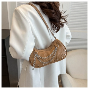 Détail d'un sac baguette marron texture crocodile avec chaînes argentées et rivets