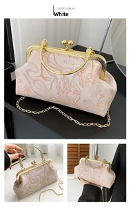 Detail of floral jacquard handbag with gold filigree frame and beaded clasp closure