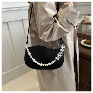 Détail du sac hobo noir avec chaîne décorative en perles et cœurs argentés