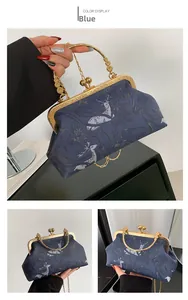 Detailed view of the blue floral jacquard handbag with vintage gold metal kiss-lock frame
