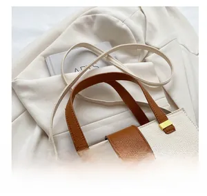 Close-up of contrast color handbag with lychee pattern leather and gold metal hardware