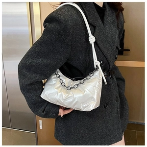Détail du sac nuage argenté métallisé avec chaîne noire sur blazer en laine