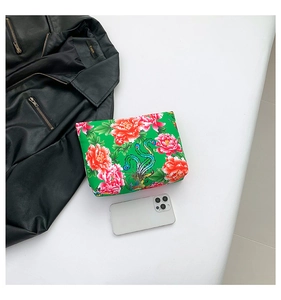 Ethnic nylon floral pouch with peony and phoenix patterns next to a smartphone