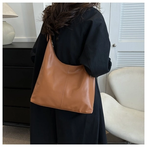 Lifestyle view of brown leather hobo bag with vertical seam detail and large capacity