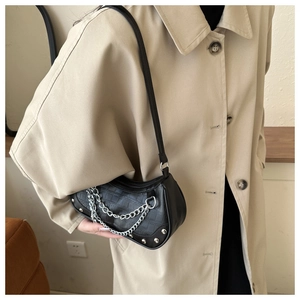 Détail du sac demi-lune noir en similicuir avec chaînes argentées et ornements de rivets