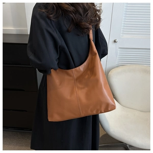 Detail shot of the tan PU leather hobo bag showing the vertical stitching and wide strap