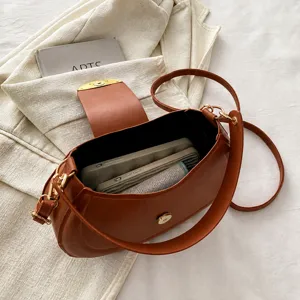 Intérieur du sac bandoulière en cuir marron montrant un grand espace de rangement