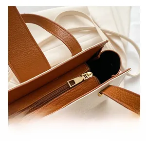 Detail of lychee pattern leather handbag with golden zipper and magnetic closure