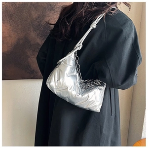 Sac nuage métallisé argenté avec chaîne porté sur un manteau noir vue de côté