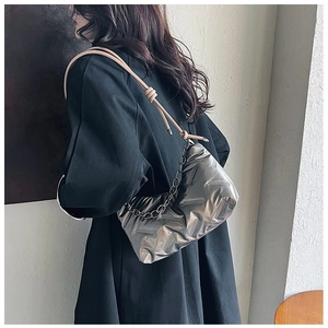 Détail du sac matelassé argenté avec chaîne métallique et bandoulière en cuir noué