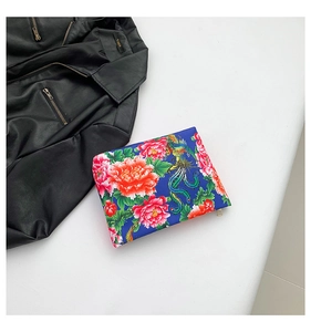 Detailed view of floral nylon clutch bag featuring traditional phoenix embroidery
