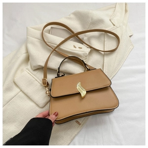 Détail du petit sac en cuir kaki avec fermoir doré en forme de feuille et bandoulière